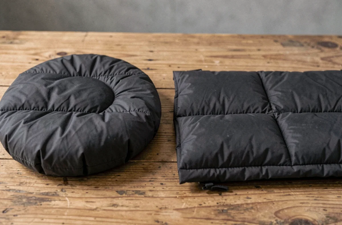 Gros plan comparatif d'une veste Moncler avec un compartiment bouffant et un compartiment plat, problème de duvet inégal